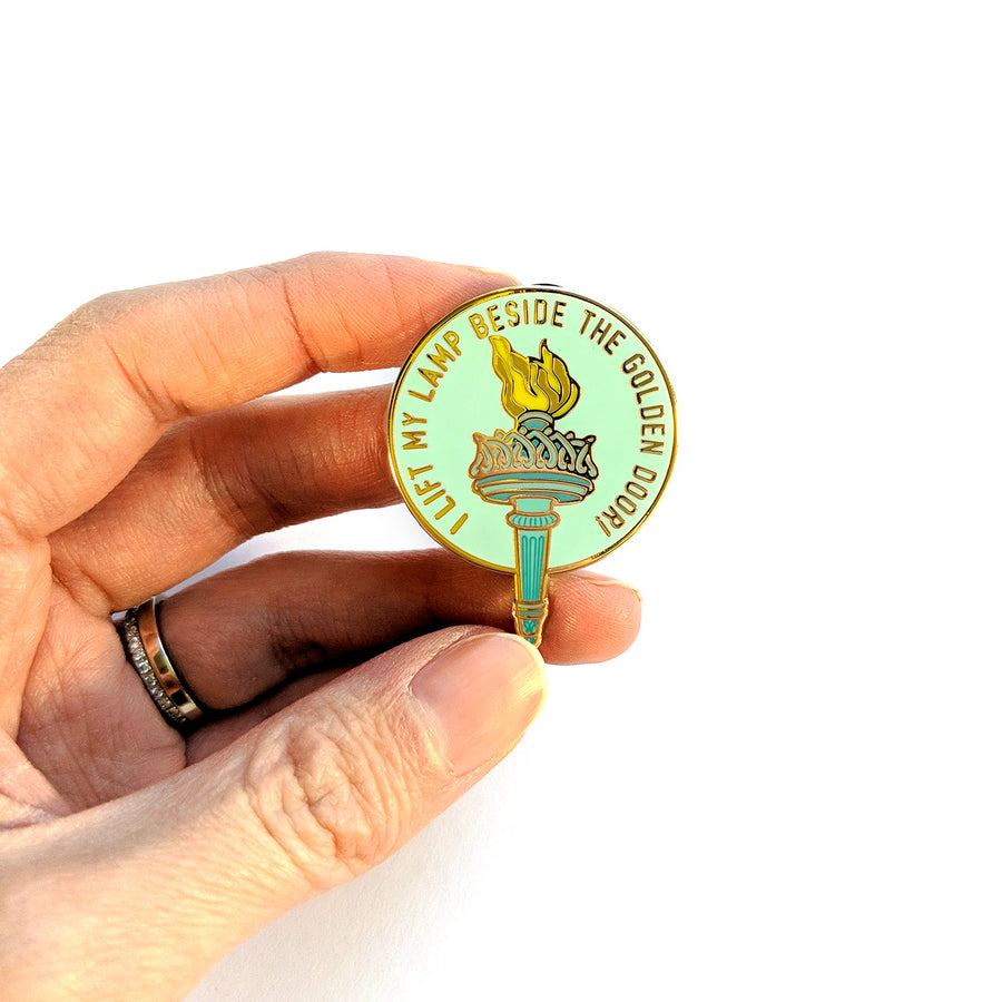 I Lift My Lamp Beside The Golden Door Pin - Geeky merchandise for people who play D&D - Merch to wear and cute accessories and stationery Paola's Pixels